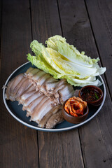 bossam is a Korean pork dish that consist of boiled thinly sliced pork belly or shoulder served with napa cabbage, kimchi and sweet spicy sauce