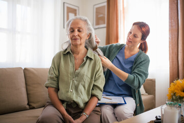 Nurse combing hair of beautiful senior woman.