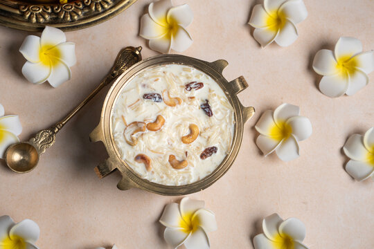 Top view of Payasam with flowers, Onam sweets dessert semiya payasam also known as Khir payasam in a golden vessel