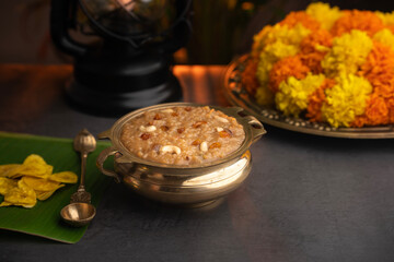 Temple Payasam arranged in a golden brass vessel with flowers on the background. Onam festival ari...