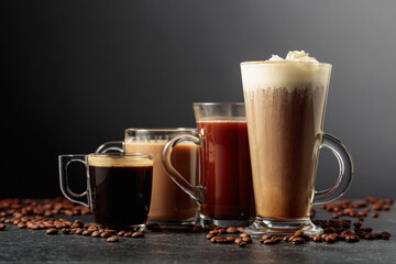 Various coffee and chocolate drinks on a black table.