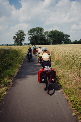 Familie fährt mit bepackten Fahrrädern über einen Radweg zwischen Münster und Coesfeld, Münsterland, Deutschland 