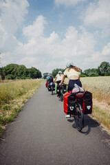 Fototapeta na wymiar Familie fährt mit bepackten Fahrrädern über einen Radweg zwischen Münster und Coesfeld, Münsterland, Deutschland 