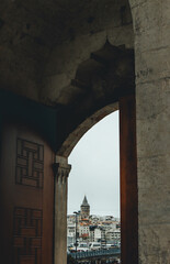 View of galata tower at horizon through the huge mosquee door 