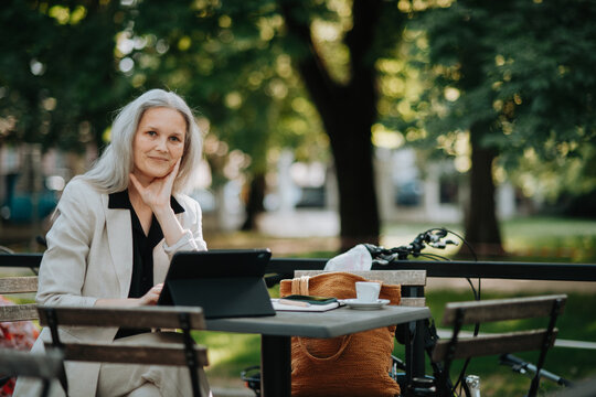 Portrait of beautiful female manager in middle age with gray hair working outdoors.