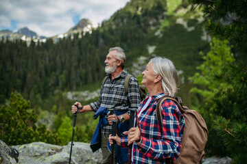 Potrait of active senior woman hiking with husband in autumn mountains.