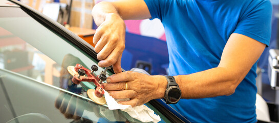 Specialist fixing crack on car windshield in repair shop