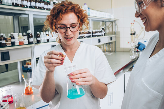 n a bustling chemistry lab, a red-haired female scientist meticulously conducts experiments, igniting her passion for scientific exploration and discovery.