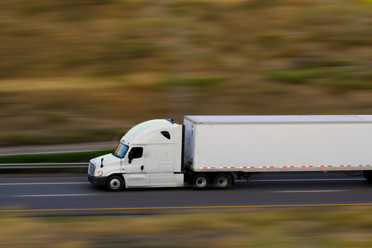 Semi Truck and Trailer Speeding Down Highway Road Blurred Blurry