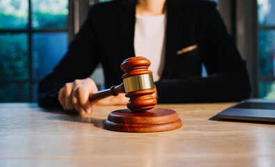 Justice and law concept.Male judge in a courtroom with the gavel, working with, computer and docking keyboard, eyeglasses, on table in morning light