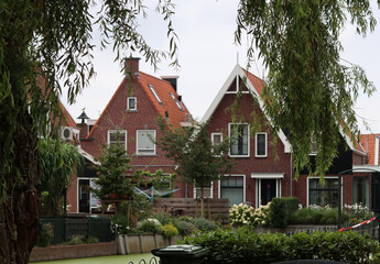 Classic Dutch houses on a street. Cute buildings with red tiles roof. Architecture of the Netherlands. 