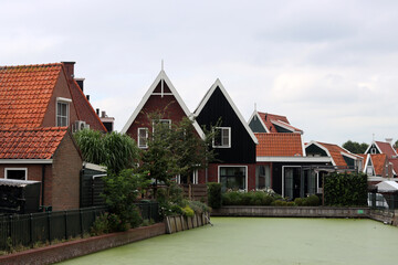 Classic Dutch houses on a street. Cute buildings with red tiles roof. Architecture of the Netherlands. 