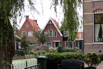 Classic Dutch houses on a street. Cute buildings with red tiles roof. Architecture of the Netherlands. 