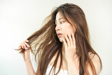 Damaged Hair, frustrated asian young woman, girl hand in holding splitting ends, messy unbrushed...
