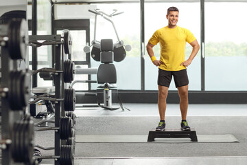 Man standing on a step aerobic platform at a gym