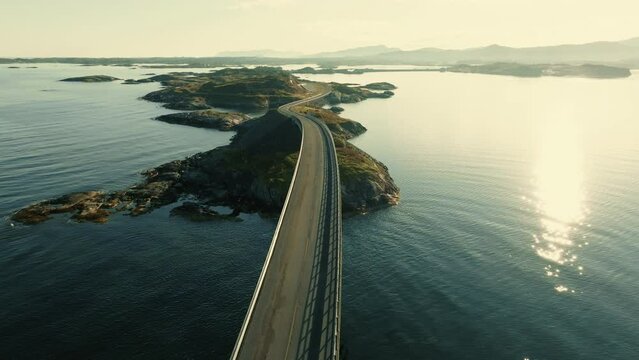 Drone flies from above along Atlantic Ocean road on the Storseisundet bridge, connecting small islands on sunny day