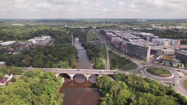 Aerial drone establishing view of Bridge Park businesses, roadway traffic, new restaurants, and hotels by the Scioto River in rich upper-class downtown Dublin, OH northwest of Columbus, Ohio