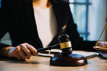 Justice and law concept.Male judge in a courtroom with the gavel, working with, computer and docking keyboard, eyeglasses, on table in morning light