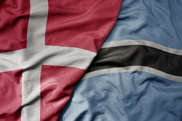 big waving national colorful flag of denmark and national flag of botswana .