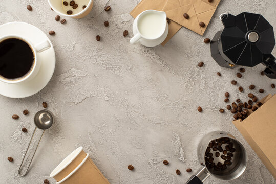 Celebrate coffee aficionado on Coffee Day with setup. Top view of coffee beans, espresso cup, coffee-to-go paper cups and more barista's tools on soft grey grunge-style backdrop, frame for text or ad