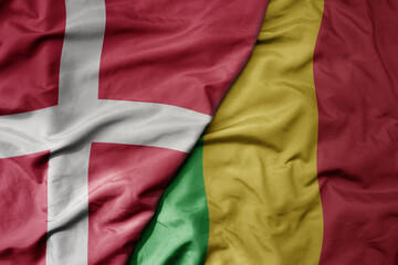big waving national colorful flag of denmark and national flag of mali .