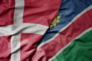 big waving national colorful flag of denmark and national flag of namibia .