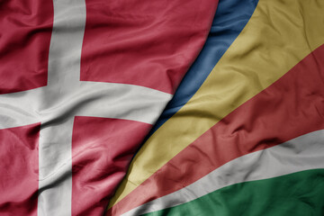 big waving national colorful flag of denmark and national flag of seychelles .