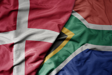 big waving national colorful flag of denmark and national flag of south africa .