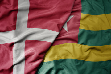 big waving national colorful flag of denmark and national flag of togo .
