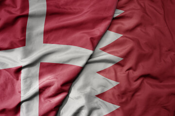 big waving national colorful flag of denmark and national flag of bahrain .