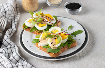 Homemade sandwiches with egg, arugula and cheese sprinkled with sesame seeds