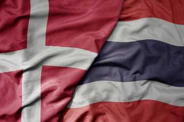 big waving national colorful flag of denmark and national flag of thailand .