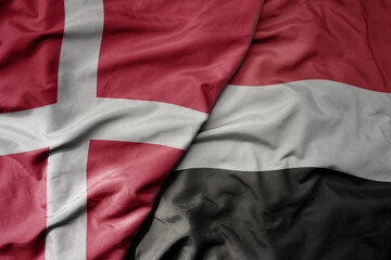 big waving national colorful flag of denmark and national flag of yemen .