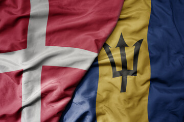 big waving national colorful flag of denmark and national flag of barbados .