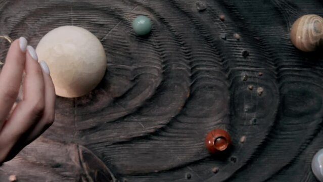 a girl touches an imitation of a galaxy made of wood with her hands