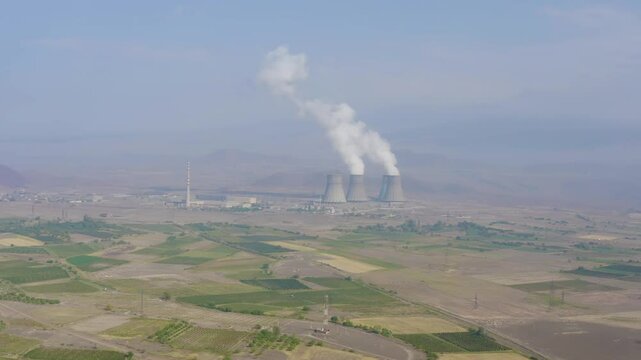 Forward reveal aerial shot of Metsamor Nuclear Power Plant on sunny summer day. Metsamor, Armenia.