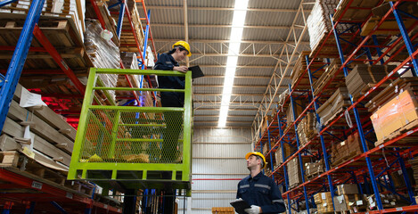 Warehouse workers using forklift to check and counting in a large warehouse. This is a large paper...