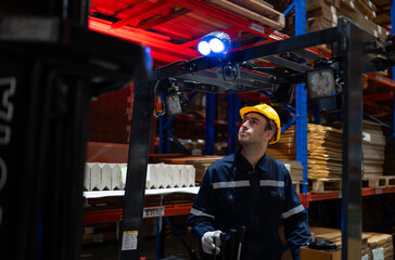 Warehouse workers using forklift to move products in a large warehouse. This is a large paper package storage and distribution warehouse.