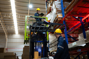 Warehouse workers using forklift to check and counting in a large warehouse. This is a large paper package storage and distribution warehouse. © Wosunan