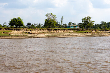 Shack between the Amazon river and the Amazon rainforest in Brazil, South America - viewed from...