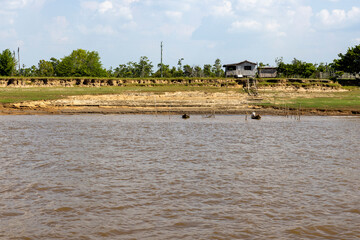 Shack between the Amazon river and the Amazon rainforest in Brazil, South America - viewed from aboard a ferry to Manaus