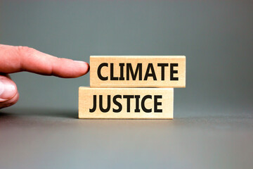 Climate justice symbol. Concept words Climate justice on beautiful wooden blocks. Beautiful grey table grey background. Businessman hand. Business environment climate justice concept. Copy space.