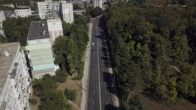 Bird's-Eye Gaze Along the Urban Parkway 🏞️🏙️.
A slow and mesmerizing drone video offers a high-altitude perspective of the city road separating a lush park area from the bustling cityscape.