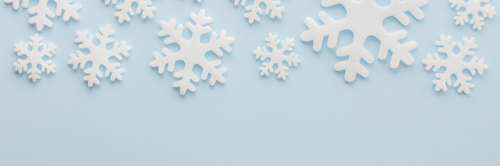 White snowflakes on a blue background, Christmas banner, Merry Christmas and Happy New Year concept, top view, copy space