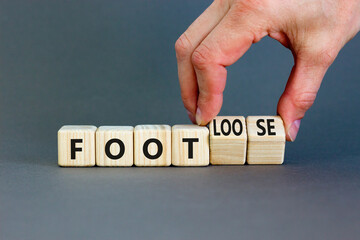 Foot or footloose symbol. Businessman turns wooden cubes and changes word Foot bad to Footloose....