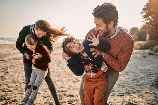 Young happy family walking on a sandy beach during winter