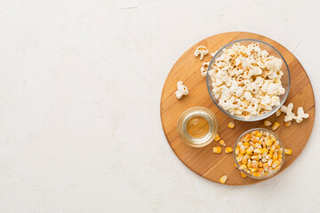 Prepared popcorn with ingredients on concrete background, top view