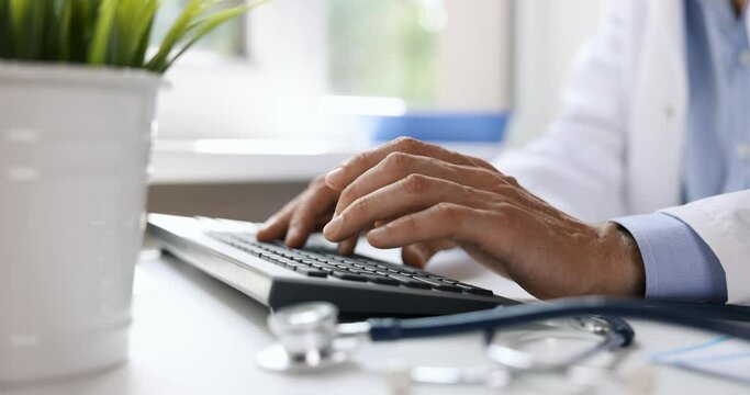 doctor typing on computer keyboard. working in clinic office. online medical consultation. slider shot