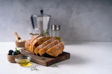 Tuinposter Homemade sourdough ciabatta slice bread with olives and rosemary on a white abstract table. Artisan bread © ILHAM_PS