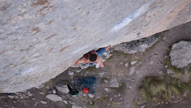Young man lead climbing a hard and steep section of the wall in C&eacute;&uuml;se, France.
Following camera movement, low angle, 4K.
